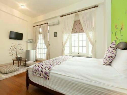 een slaapkamer met een groot bed en een groot raam bij Together B&B in Hualien