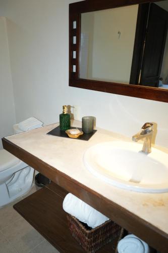 a bathroom counter with a sink and a mirror at Hotel Boutique La Puerta Azul Beachfront - Adults Only in Holbox Island