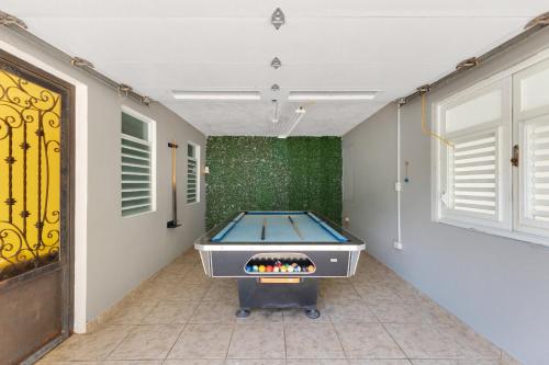 a pool table in a room with a green wall at Hacienda M&B Perfect for Groups, with Pool and Spacious Patio in Vega Baja