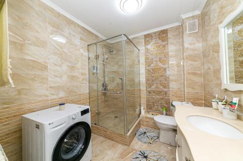 a bathroom with a shower and a washing machine at Er Targyn 19 in Astana