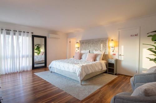 a bedroom with a white bed and a large window at Hilltop Hacienda – Private Villa Panoramic Views in San Diego