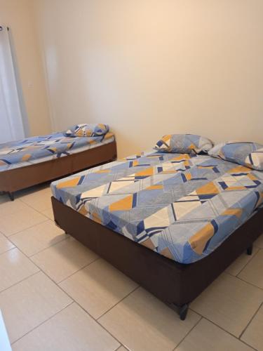 two twin beds in a room with at Espaço nossa senhora aparecida a 4 min da basilica in Aparecida