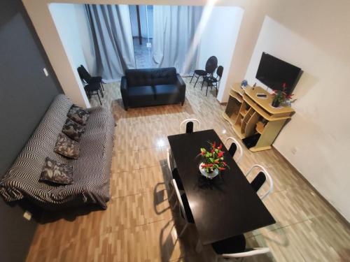 a living room with a table and chairs and a television at Temporada Caminho de Búzios in Cabo Frio