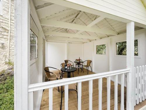 a porch with a table and chairs on it at The Gate House in Llandegla