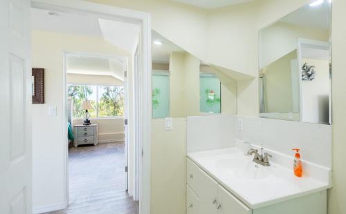 Un baño blanco con lavabo y espejo. en Villa Turkuaz Entire Beach Front Villa, en Long Bay Hills