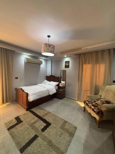 a bedroom with a bed and a couch and a chair at Fifth Settlement Guest Rooms in New cairo