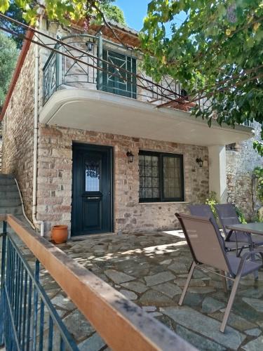 a patio with a table and chairs in front of a house at Το Αρχοντικό της Λενιώς in Taxiárkhis