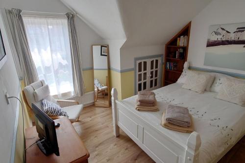 a bedroom with a white bed and a tv at House - Sleeps 8 - Pet friendly - Garden - Parking in Bexhill