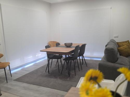 a table and chairs in a living room with a couch at Casa Sol em Castelo Branco in Castelo Branco