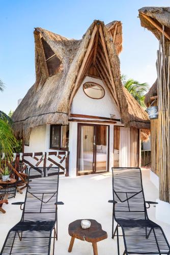 a group of chairs and a table on a patio at Hotel Villas Flamingos in Holbox Island