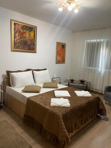 a bedroom with a large bed with towels on it at Lemora Apartments 2 in Focşani