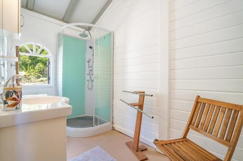 a bathroom with a shower and a sink and a chair at Villa Beau Rivage in La Moïse