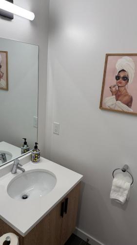 a bathroom with a sink and a mirror at Modern & Spacious 2BR Apartment with Gym & Parking in New Haven
