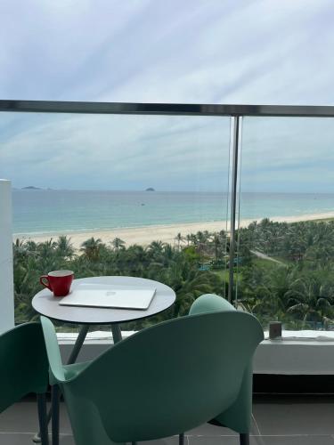 a table and chairs with a view of the beach at K' SEA VIEW ARENA RESORT o in Miếu Ông