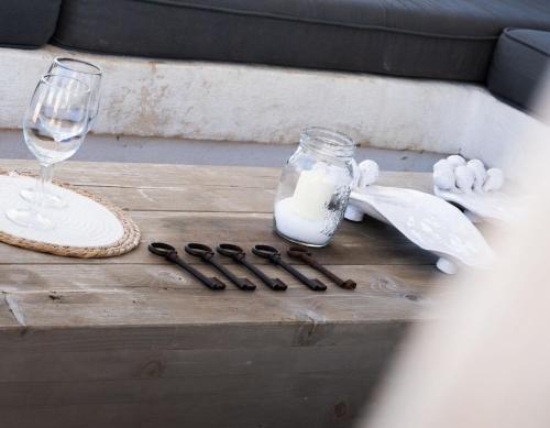 a wooden table with a glass of wine and a bottle and some knives at Villa San Vito Due in Ostuni