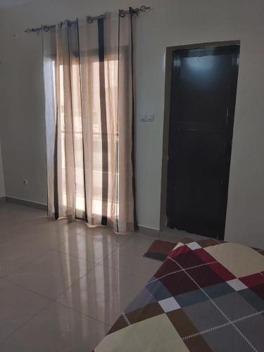 a room with a door and a window with a rug at Al houda in Dakar