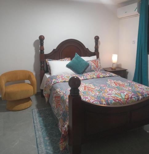 un dormitorio con una cama y una silla en 4K-Suite, en Kingston