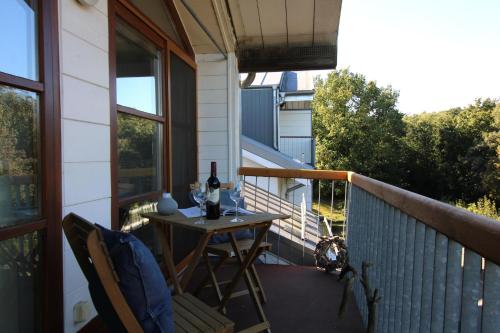 a table on a balcony with a bottle of wine at Am Grün 15 Fewo 25 in Wittenbeck