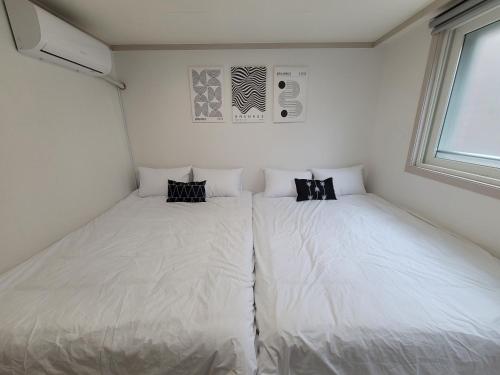 a bedroom with two white beds in it at Mi casa in Seoul