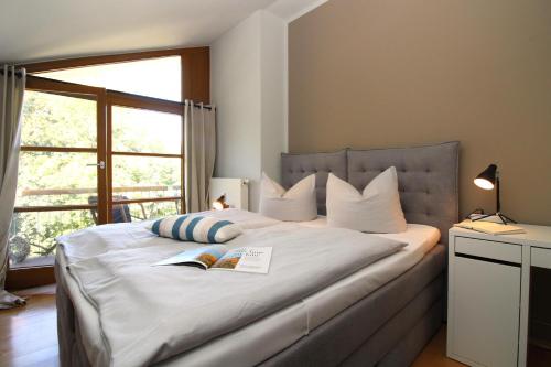 a bedroom with a large bed with two books on it at Am Grün 15 Fewo 25 in Wittenbeck