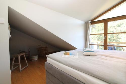 a bed in a room with a large window at Am Grün 15 Fewo 25 in Wittenbeck
