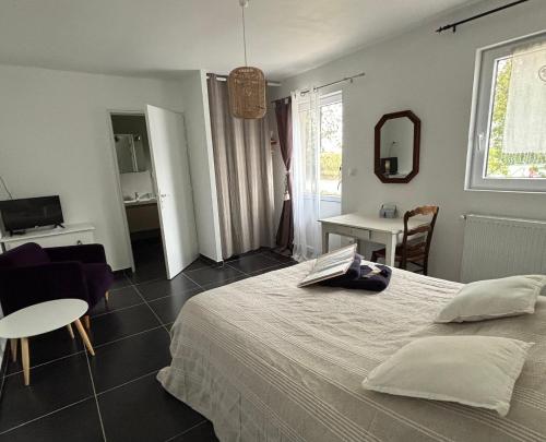 a bedroom with a bed and a table and a chair at la ferme au bois dormant in Wemaers-Cappel