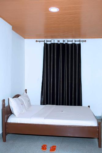 a bed in a room with a black curtain at The Moon Geust House in Gisenyi