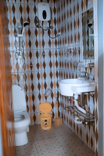 a bathroom with a toilet and a sink at The Moon Geust House in Gisenyi