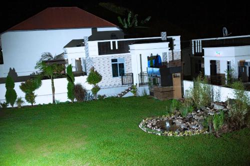 a large white house with a yard with a yard at The Moon Geust House in Gisenyi