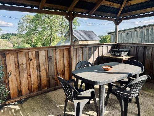 ein Tisch und Stühle auf einer Terrasse mit Grill in der Unterkunft Petite maison de campagne in Giat