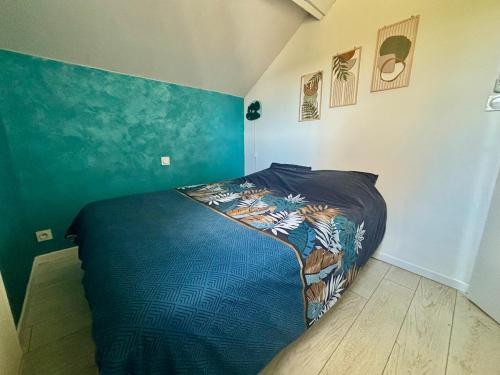 ein Schlafzimmer mit einem Bett in einem Zimmer mit blauen Wänden in der Unterkunft Petite maison de campagne in Giat