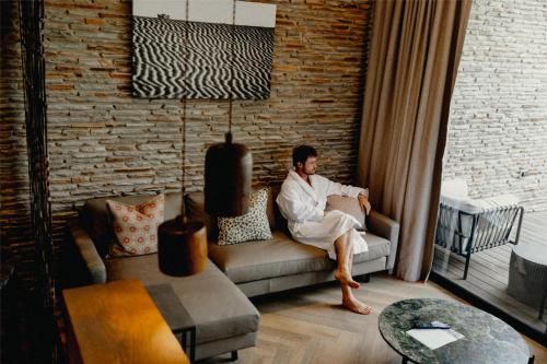 a man sitting on a couch in a living room at Radisson Safari Hotel Hoedspruit in Hoedspruit