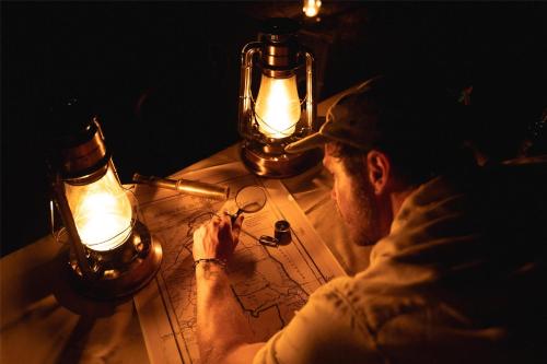 a man sitting at a table with lights on it at Radisson Safari Hotel Hoedspruit in Hoedspruit
