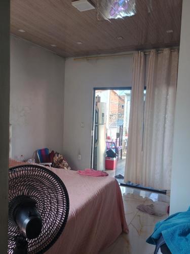 Un dormitorio con una cama y una ventana grande. en Quarto para alugar para cop 30, en Ananindeua