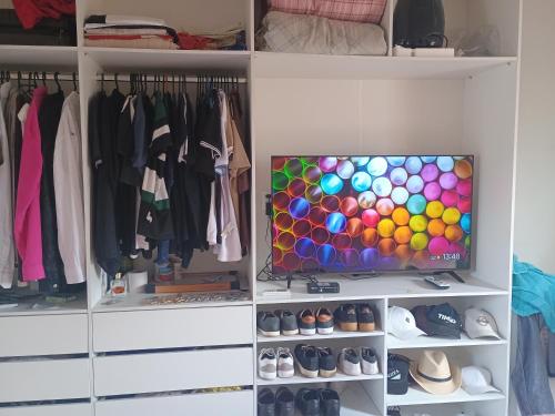 Un armario con un televisor en el medio. en Quarto para alugar para cop 30, en Ananindeua