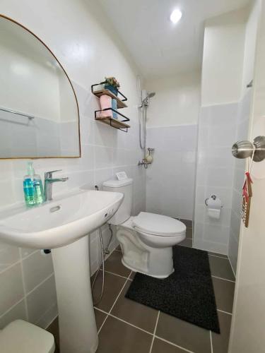 a white bathroom with a sink and a toilet at HarborPoint Mactan in Mactan