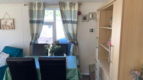 a room with a table and chairs and a window at Ednas Lodge in Wisbech