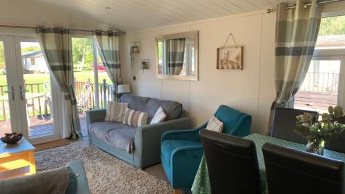 a living room with a couch and chairs at Ednas Lodge in Wisbech