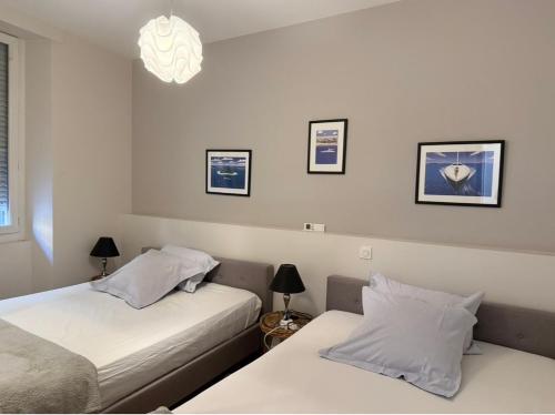 Un dormitorio con dos camas y una lámpara de araña. en Cannes Old Port, enjoy SEAFRONT & SEAVIEWS, en Cannes