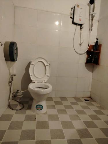 a bathroom with a toilet and a phone on the wall at Ban Laos Guesthouse in Vang Vieng