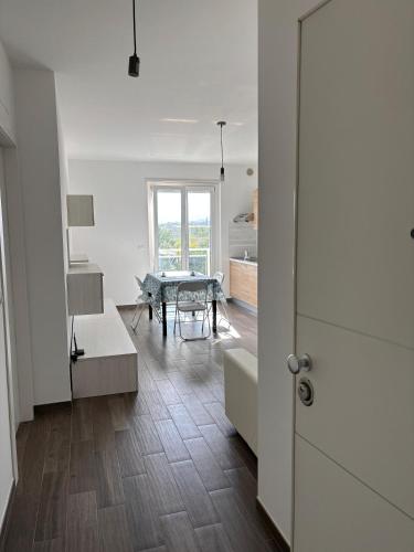 a white living room with a table and a door at Al Bivio Blu in Chieti