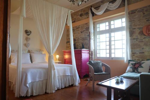 ein Schlafzimmer mit Himmelbett und Fenster in der Unterkunft Traditional cottage house in front of the beach in Ríva