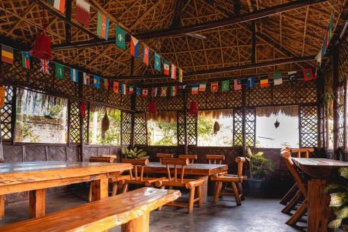 a restaurant with tables and chairs and flags hanging from the ceiling at Paat Halodhiya Farm Stay in Kāhārpāra