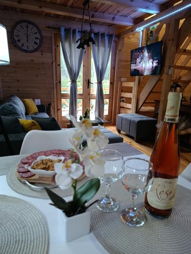 a table with a plate of food and a bottle of wine at Dedin Konak in Mokra Gora
