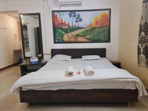 a bedroom with a large bed with two towels on it at The Wilds Villa Gir Jungle Stay with Swimming Pool in Sasan Gir