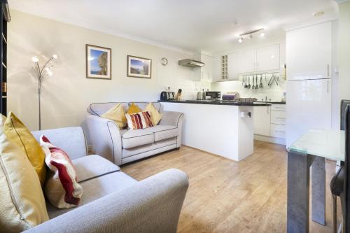 a living room with two couches and a kitchen at The Screes - Short stroll from Wastwater in Nether Wasdale