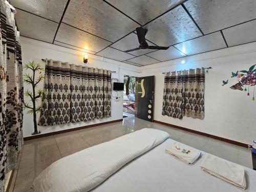 a living room with a large white bed in a room at The Wilds Villa Gir Jungle Stay with Swimming Pool in Sasan Gir