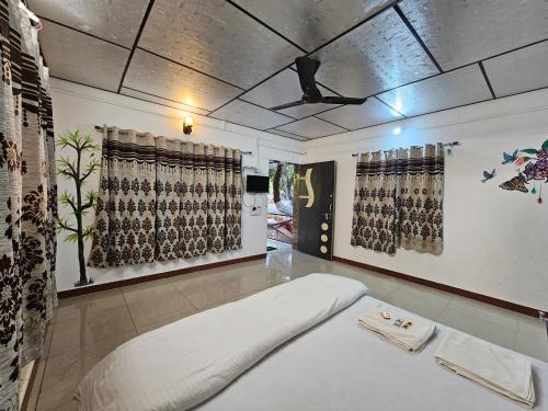 a room with a bed and a ceiling with curtains at The Wilds Villa Gir Jungle Stay with Swimming Pool in Sasan Gir