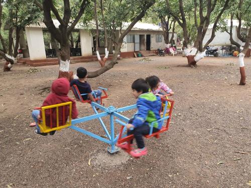 a group of children playing on a playground at The Wilds Villa Gir Jungle Stay with Swimming Pool in Sasan Gir