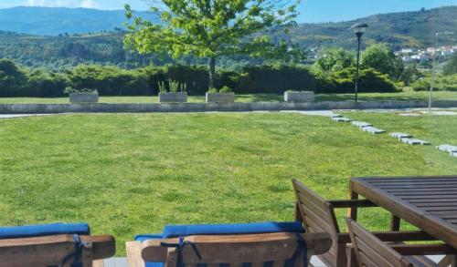 a picnic table and chairs in a field of grass at Lugar Nas Estrelas Starlight Outdoor Fireplace in Peso